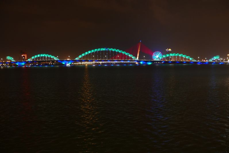 Die Drachenbrücke wird abends in unterschiedlichen Farben angestrahlt